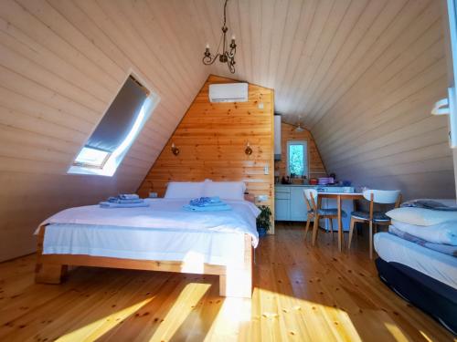 - une chambre avec un lit et une table dans l'établissement Linistea Muntilor Chalet, à Porumbacu de Sus