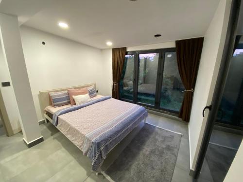 a bedroom with a bed in a room with windows at Muhafazakar Müstakil Aile Villası 