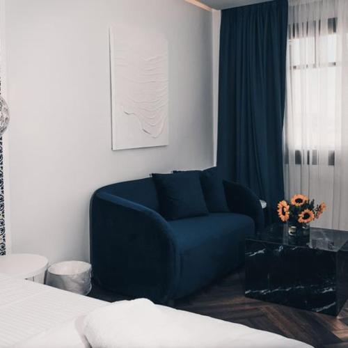 a blue couch in a room with a bed at BLUE LUXURY SUITES in Preveza