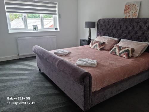 a bedroom with a large bed with two towels on it at 4 bed private home in Colchester in Colchester