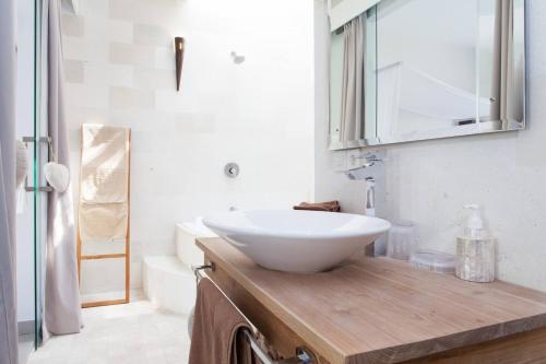 un bagno con lavandino bianco su un bancone in legno di Villa KMEA 4 a Seminyak