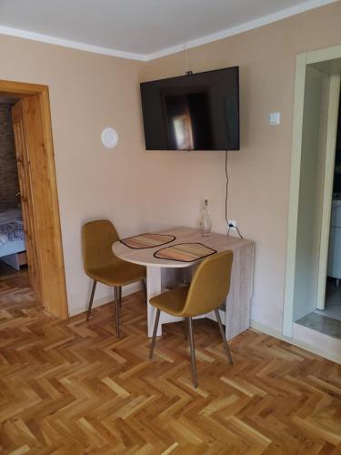 a dining room with a table and two chairs and a television at Mimi appartman in Doboj
