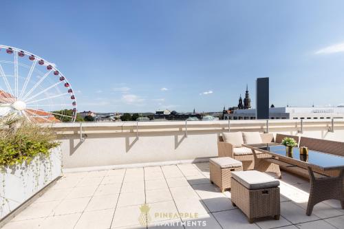 une terrasse avec une roue ferris en arrière-plan dans l'établissement Pineapple Apartments Penthouse am Zwinger - 162 qm - 1x free parking, à Dresde