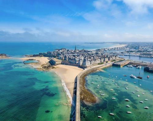 une vue aérienne d'une plage avec des bateaux dans l'eau dans l'établissement Appartement en bord de mer entre Saint Malo et le Mont Saint Michel, à Saint-Benoît-des-Ondes