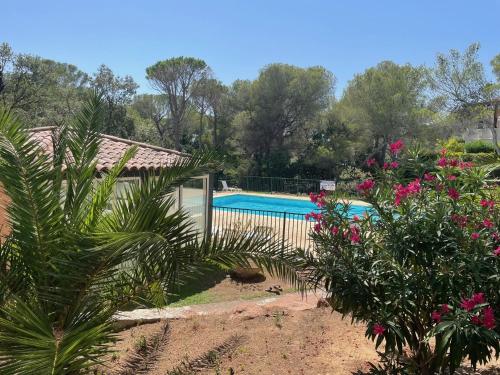 un jardin avec une piscine et des fleurs dans l'établissement 2 pièces Saint Raphael rénové, classé 4 étoiles, 100 m plages, piscine, tennis, parc, terrasse, jardin privatif, à Saint-Raphaël