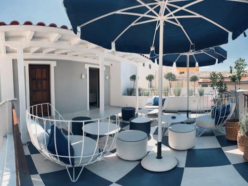 普雷韋扎的住宿－BLUE LUXURY SUITES，庭院配有桌椅和遮阳伞。