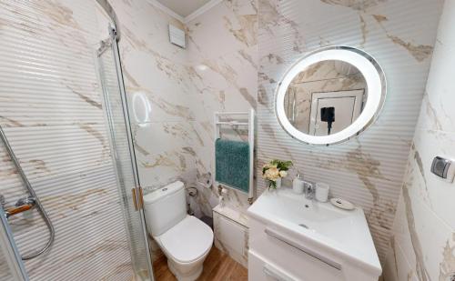 a bathroom with a toilet and a sink and a mirror at Апартамент в топ център София 5 Corners in Sofia
