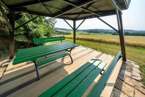 eine grüne Parkbank auf einer Holzterrasse in der Unterkunft Obytný posed Šach in Dačice