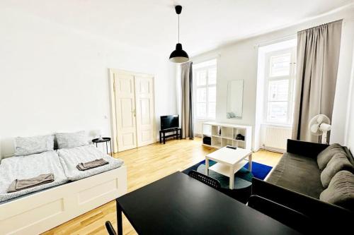 uma sala de estar com um sofá e uma mesa em Best Location - Cozy City Centre Apartment em Viena