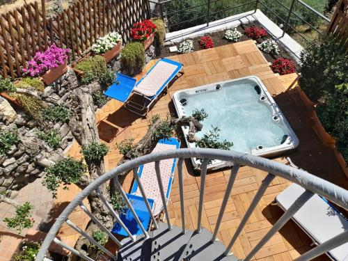 a balcony with a swimming pool and chairs and plants at Palmento House Amazing View and Private Mini SPA in Piedimonte Etneo