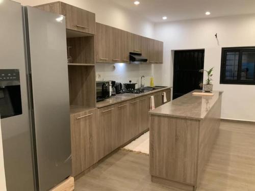 a kitchen with wooden cabinets and a stainless steel refrigerator at Villa moderne securisee 24H sur 7J 