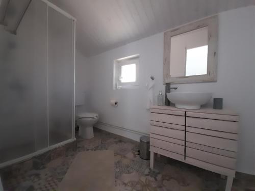a white bathroom with a sink and a toilet at Casa Davina in Sasca Montană