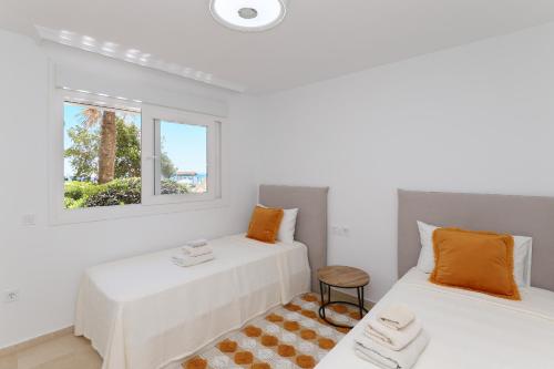 2 camas en una habitación con 2 ventanas en Luxury with pool view - Playa Real beachfront, en Marbella