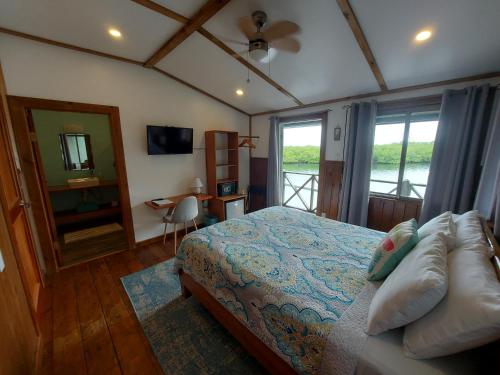 een slaapkamer met een bed, een spiegel en een raam bij The Sunsetter Bed & Breakfast in Bocas del Toro