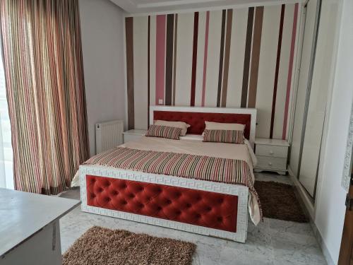 a bedroom with a large bed with a red headboard at Appart de Luxe au Centre Urbain Nord in Tunis