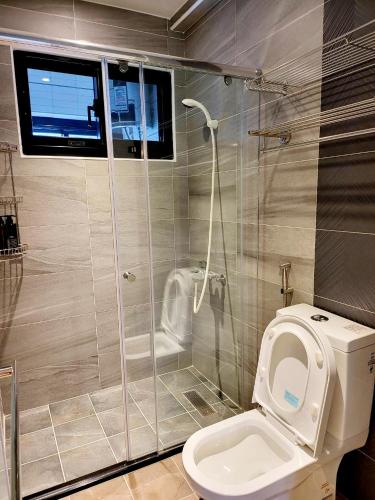 a bathroom with a toilet and a glass shower at Annong Image Vacation Home in Sanxing
