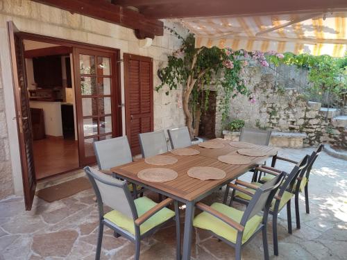 einen Holztisch und Stühle auf einer Terrasse in der Unterkunft Villa Rustika in Sutivan
