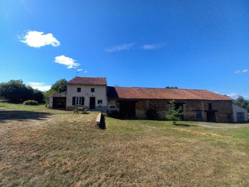 une ancienne maison en pierre sur une pelouse dans l'établissement La petite halte, à Bellac