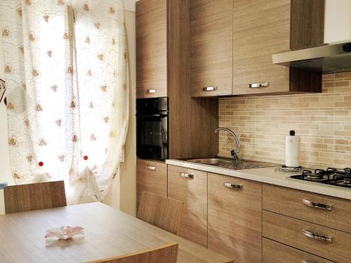 una cocina con armarios de madera y una mesa con fregadero en La Torre en Maiori