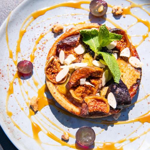 a white plate with a sandwich with nuts and sauce at ibis Aix en Provence in Aix-en-Provence