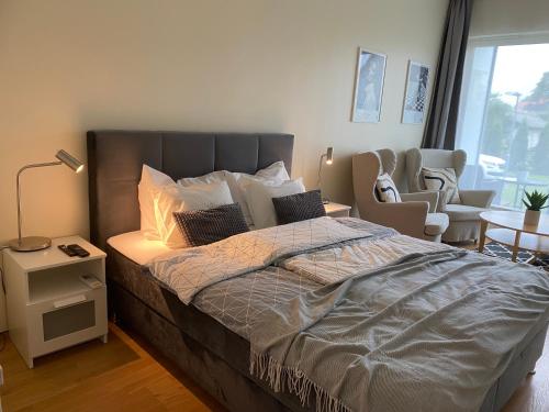 a bedroom with a large bed and a chair at Lovely Aisa apartment in Pärnu in Pärnu