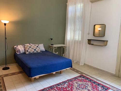 een slaapkamer met een blauw bed in een kamer bij An authentic old Jaffa apartment in Tel Aviv