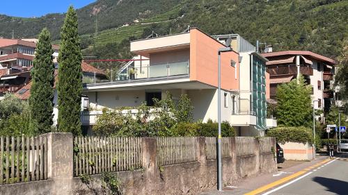 une maison sur le côté d'une rue avec une clôture dans l'établissement Garden Suite, à Bolzano