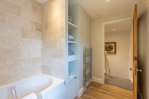 a bathroom with a tub and a walk in shower at Bell Cottage - Pretty Period Cottage DOG FRIENDLY in Northallerton