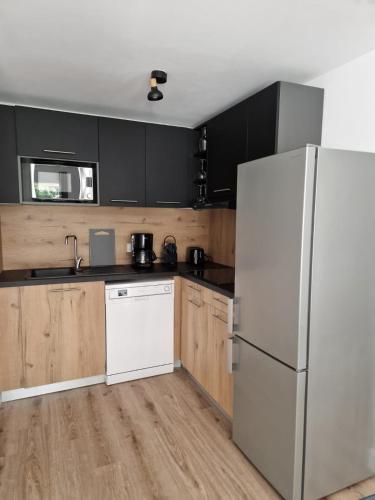 La cuisine est équipée d'un réfrigérateur blanc et de placards en bois. dans l'établissement Résidence Fiori di Cala Rossa, à Lecci