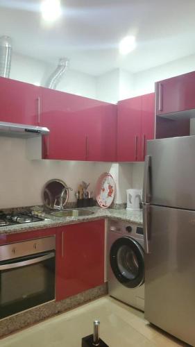 a kitchen with pink cabinets and a washing machine at Kariat Cabo - Apartment in Cabo negro in Cabo Negro