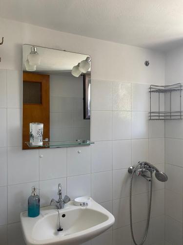 a bathroom with a sink and a shower with a mirror at Yfantis Sakis Apartment's in Erateini