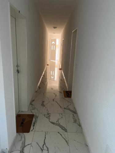 pasillo con pared blanca y suelo de mármol en Villa Abi Center, en Struga
