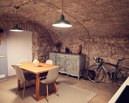 - une salle à manger avec une table en bois et un vélo dans l'établissement La Dolce Vita. Boutique Apartment, à Gérone