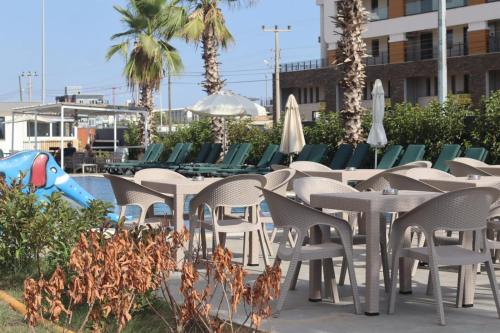 a group of chairs and tables with umbrellas at Ethica Suite Luxury Houses in Aksu
