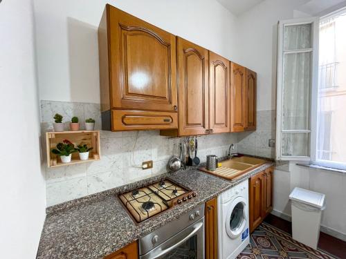 a kitchen with wooden cabinets and a washer and dryer at La Casa di Eli Appartamenti in Pisa