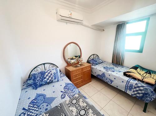 a bedroom with two beds and a mirror at Concorde (Royal Beach) chalet Ras Sedr - South Sinai in Ras Sedr