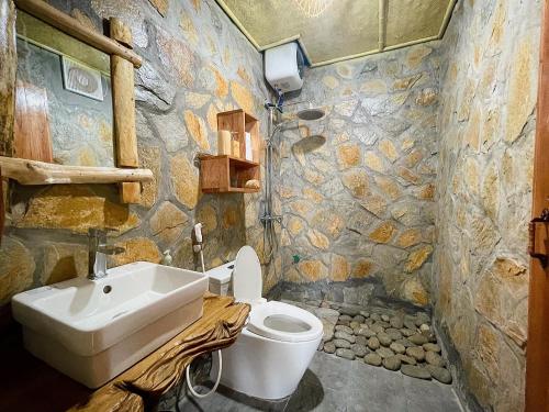 een stenen badkamer met een wastafel en een toilet bij PuBin Paradise in Hòa Bình