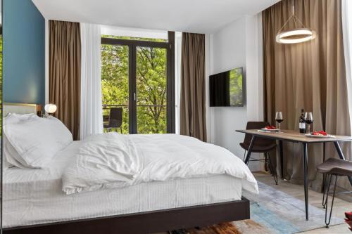 ブカレストにあるUni88 Apart Hotelのベッドと机と窓のある寝室