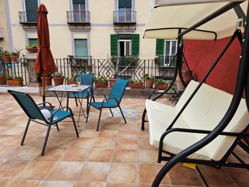 a patio with a table and chairs and an umbrella at The Spanish Palace, Suites, Rooms, Apartments & Terraces in Naples
