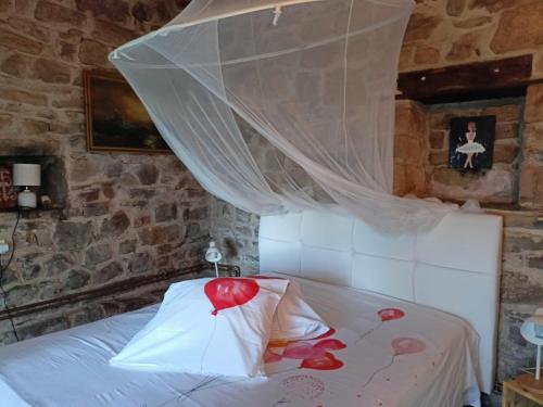- une chambre dotée d'un lit avec un voile au-dessus dans l'établissement La longère d'Anaïde, à Saint Marcel Campes