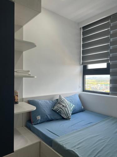 Cama en habitación con ventana con persianas en Chi Homestay Nera Garden Huế, en Hue