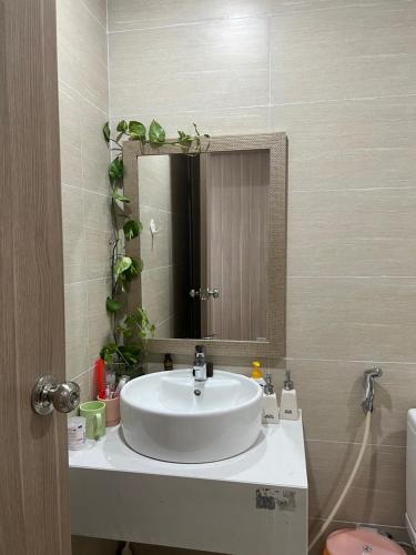 y baño con lavabo blanco y espejo. en Chi Homestay Nera Garden Huế, en Hue
