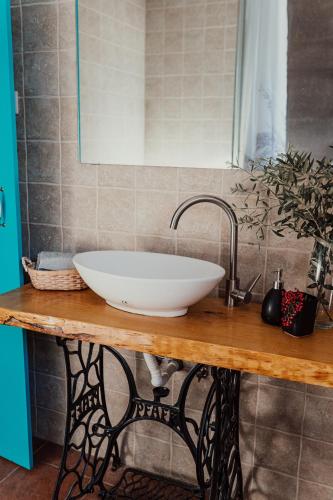 a white bowl sink on a wooden counter in a bathroom at Casa Margarida in Albernoa