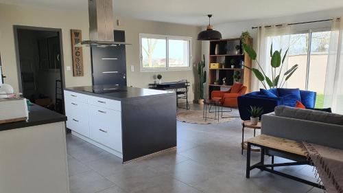 une cuisine et un salon avec un canapé dans l'établissement Villa de l'Herm - ADRIAE Home, à Saint-Michel-en-lʼHerm