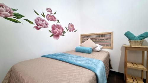 a bedroom with a bed with flowers on the wall at Central Hostel Reforma in Guatemala