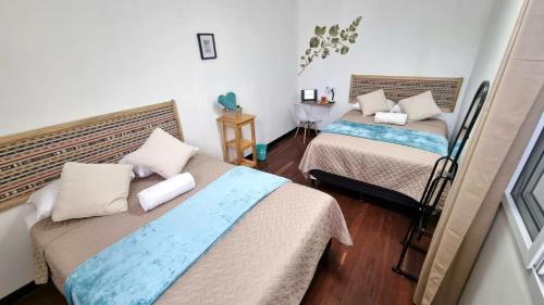 a bedroom with two beds and a table in it at Central Hostel Reforma in Guatemala