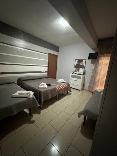 ein Schlafzimmer mit einem Bett und zwei Stühlen darin in der Unterkunft B&B Emmanuel in Reggio di Calabria
