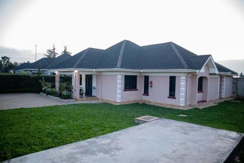 a white house with a black roof at Blueberry Villas in Eldoret