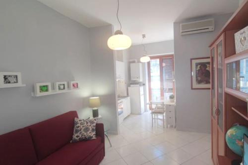 sala de estar con sofá rojo y cocina en INN pieno centro- appartamento, en Foggia