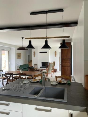 une cuisine avec un évier et une salle à manger dans l'établissement Gîte La Coulée des Robins, à Continvoir